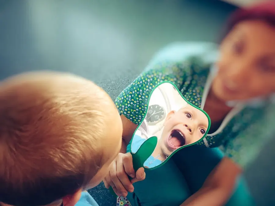 Un copil se privește în oglindă în timpul consultului la Eurosmile